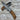 Folding knife with brown handle and silver blade on a wooden surface