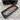 Folding knife with wooden handle in a black box on a wooden surface
