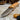 Handcrafted Böhler N690 bushcraft knife with olive wood handle, leather sheath, and magnesium fire starter